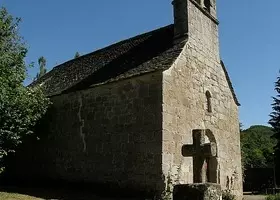 Chapelle en pierre de Bassignac, une croix sculptée sur sa façade