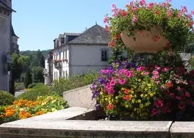 Rue du bourg de Champs-sur-Tarentaine, avec une grande jardinière fleurie au premier plan