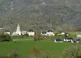 Le bourg de La Monselie et le clocher de son église, au pied d’un versant boisé